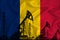 Silhouette of drilling rigs and oil derricks on the background of the flag of Romania. Oil and gas industry. The concept of oil