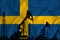 Silhouette of drilling rigs and oil derricks on the background of the flag of Sweden. Oil and gas industry. The concept of oil