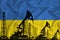 Silhouette of drilling rigs and oil derricks on the background of the flag of Ukraine. Oil and gas industry. The concept of oil