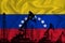 Silhouette of drilling rigs and oil derricks on the background of the flag of Venezuela. Oil and gas industry. The concept of oil