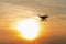 Silhouette drone against the background of the sunset. Flying drones in the evening sky.