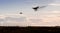 A silhouette of a drone rapidly moving towards an departing aircraft near a airport.