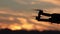 Silhouette of a drone with a sunset in the background