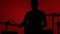 Silhouette drummer playing drum on a red background. Studio shot footage