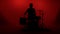 Silhouette drummer playing drum on a red background. Studio shot footage