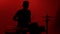 Silhouette drummer playing drum on a red background. Studio shot footage