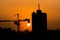 Silhouette dusk construction site of crane over sunset background