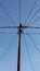 Silhouette of an electric pole with messy wires in the rice field photo from below