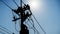 Silhouette electrical workers installing equipment on utility poles