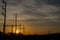 Silhouette of electricity posts during golden sunset