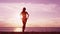 Silhouette of elegant woman at beach looking at beautiful sunset