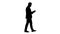 Silhouette Elegant young businessman using his PC tablet while walking.