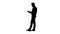 Silhouette Elegant young businessman using tablet while walking.