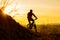 Silhouette of Enduro Cyclist Riding the Mountain Bike on the Rocky Trail at Sunset. Active Lifestyle Concept. Space for Text.