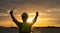 Silhouette of an engineer holding radio communications by the sea at sunset.