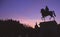 Silhouette of equestrian statue at sunset