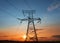The silhouette of the evening electricity transmission pylon. Power transmission from a power plant to a city