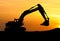 Silhouette of Excavator loader at construction site with raised