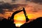 Silhouette of excavator loader  in the construction site on the sky sunset background