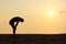 Silhouette of an exhausted sportsman at sunset