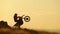 Silhouette of Extreme Motocross Biker jumping motor bike on sunrise background