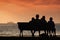 Silhouette of family on a bench by the sea