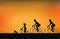 Silhouette of family driving bike with beautiful sky at sunset .