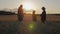 Silhouette family farmers working in a wheat field at sunset. Young parents with their daughter in a wheat field. The