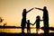 Silhouette family, including his father, mother and two children in the hands of