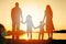 Silhouette family, including his father, mother and two children in the hands of