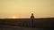 Silhouette farmer agronomist looking harvest at sunset wheat barley field alone.