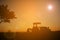 Silhouette of farmer driving tractor on field