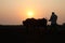 Silhouette of a farmer plows his field with a pair of Buffalo in preparation planting in India