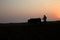Silhouette of a farmer plows his field with a pair of Buffalo in preparation planting in India