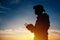 Silhouette of farmer using drone remote control