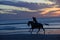 A silhouette of a fast moving horseback rider on a Florida beach at sunrise