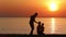 silhouette of father cleaning nose to kid on beach at sunrise