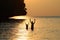 Silhouette Father and daughter enjoy swimming and snorkeling near the beach with sunset