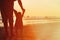 Silhouette of father and little daughter at sunset