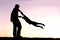 Silhouette of Father Playing with Child Outside at Sunset