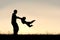 Silhouette of Father Spinning CHild Around Outside