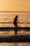 Silhouette of female swimmer having a splash in the Atlantic ocean in Ireland