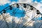 Silhouette of ferris wheel rotating against blue sky with clouds