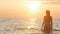 Silhouette figure of a woman coming out from the water in a swimsuit at dawn, a girl swimming in the sea enjoying sunrise, the con