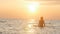 Silhouette figure of a woman coming out from the water in a swimsuit at dawn, a girl swimming in the sea enjoying sunrise, the con