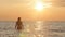 Silhouette figure of a woman coming out from the water in a swimsuit at dawn, a girl swimming in the sea enjoying sunrise, the con