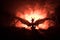 Silhouette of fire breathing dragon with big wings on a dark orange background. Horror image