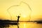 Silhouette fisher man throwing dip net fishing at lake with mountain and sunset sky
