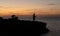 Silhouette of a fisherman with another group behind him at sunset