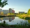 Silhouette of a fisherman on the background of reflecting in the pond multi-storey buildings